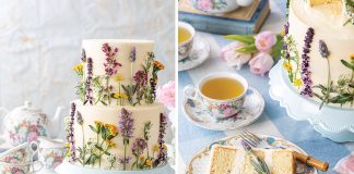A blue and white checked table set for teatime with a white cake inlaid with edible blossoms atop a blue cake stand.
