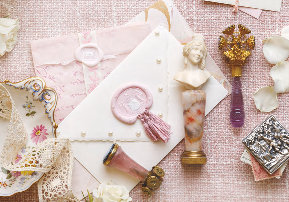wax seal stamps, envelopes, lace, and petals.