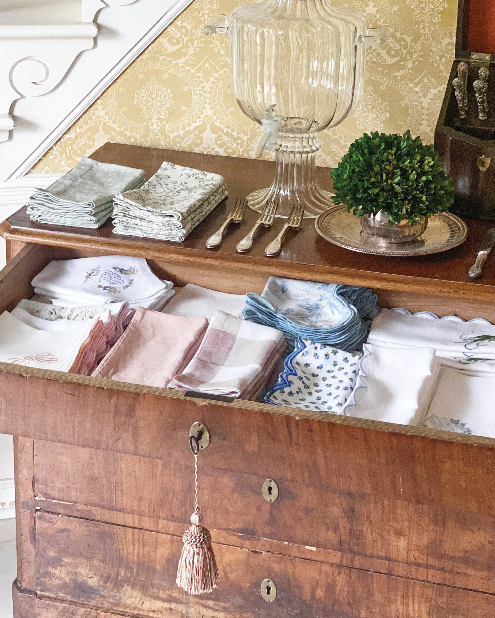 An open drawer showcases stacks of pastel linen napkins.