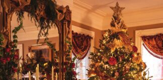 A Victorian Christmas tree and elaborately decorated fireplace mantel.
