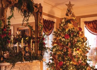 A Victorian Christmas tree and elaborately decorated fireplace mantel.