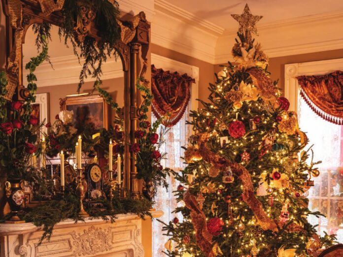A Victorian Christmas tree and elaborately decorated fireplace mantel.
