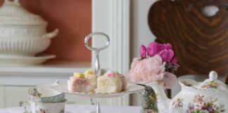 Tea cups and tea pot with pastries on a table