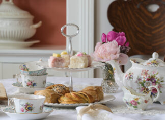 Tea cups and tea pot with pastries on a table