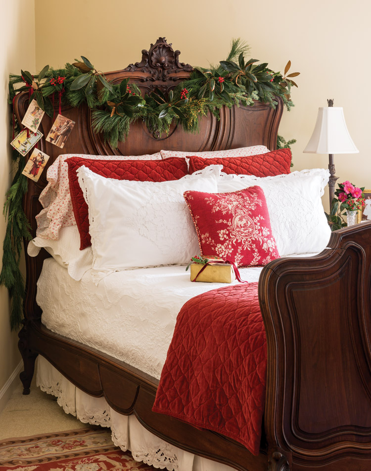 An antique bed adorned with a garland and Christmas cards.
