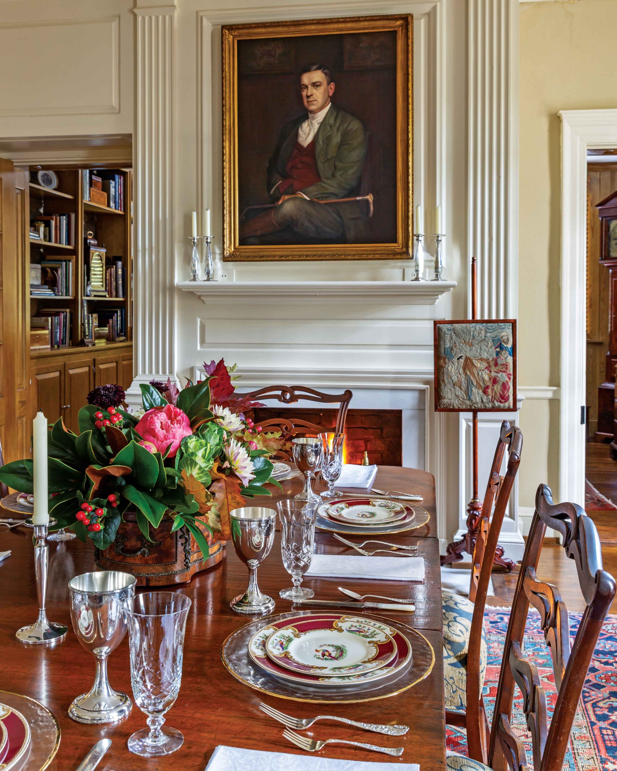 A family member’s portrait hangs above the fireplace in the formal dining room, which is set for supper.