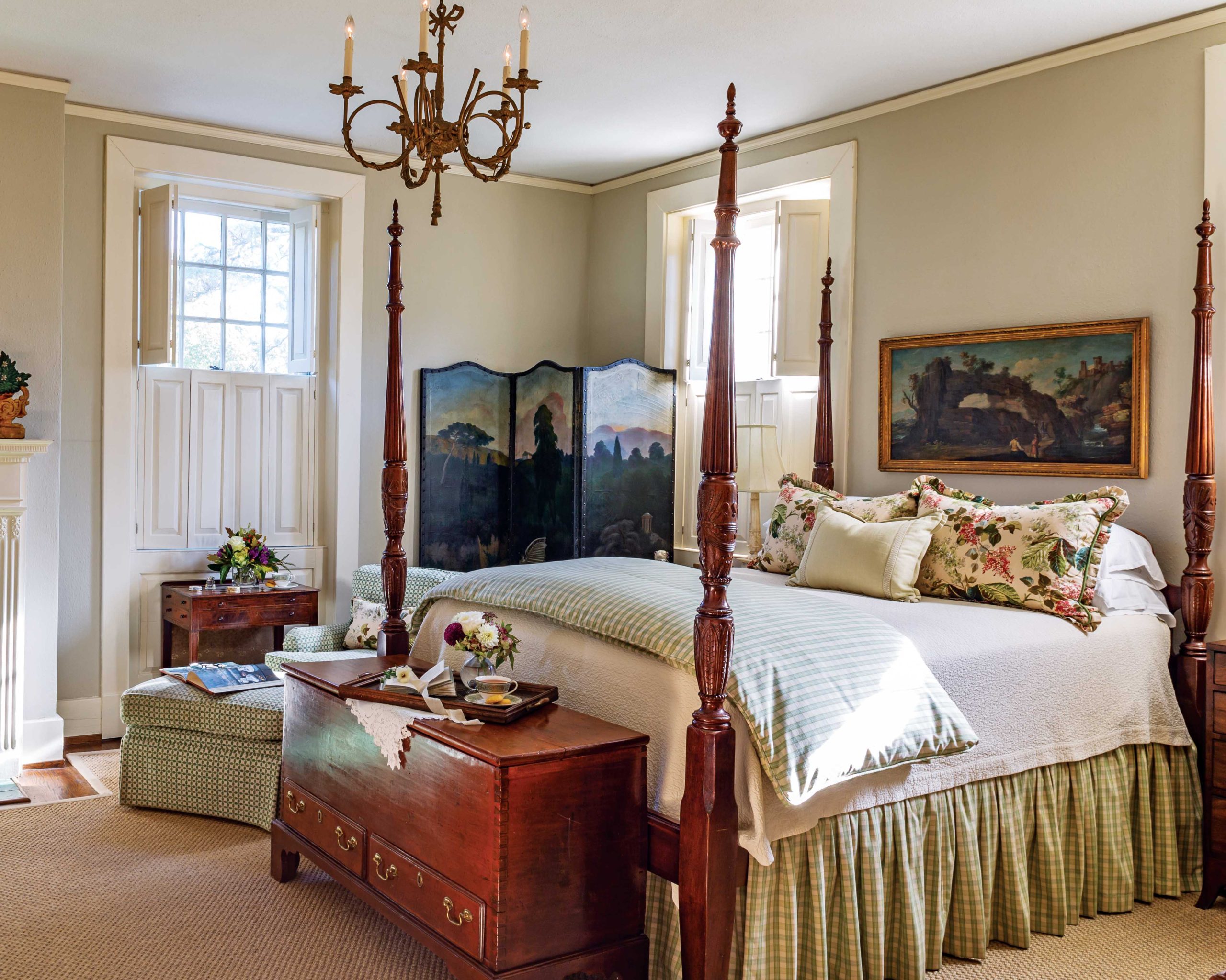 The primary bedroom in this home features a four-poster bed and lovely antiques.