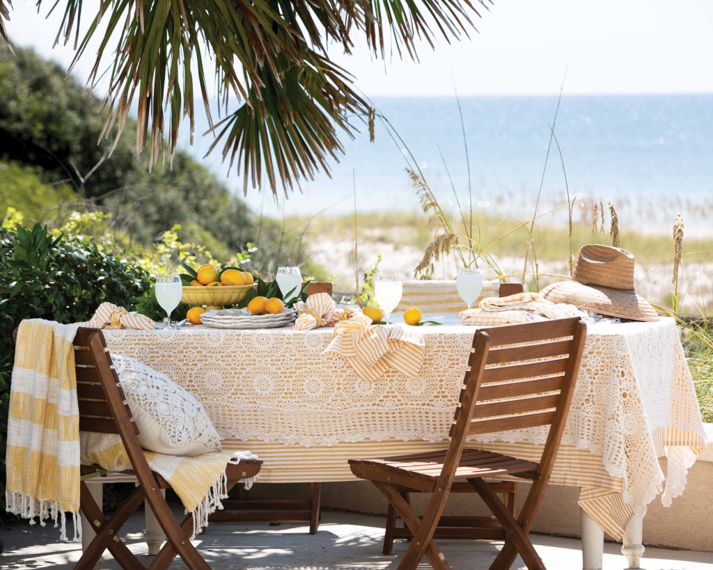 Set on the shores of the sea, this yellow and white table is drenched in sunlight and the hopes of a restful vacation meal.