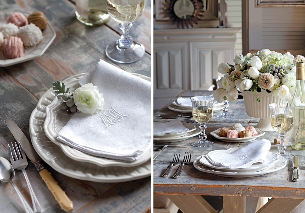 A primarily white flower arrangement sits atop an alabaster table.