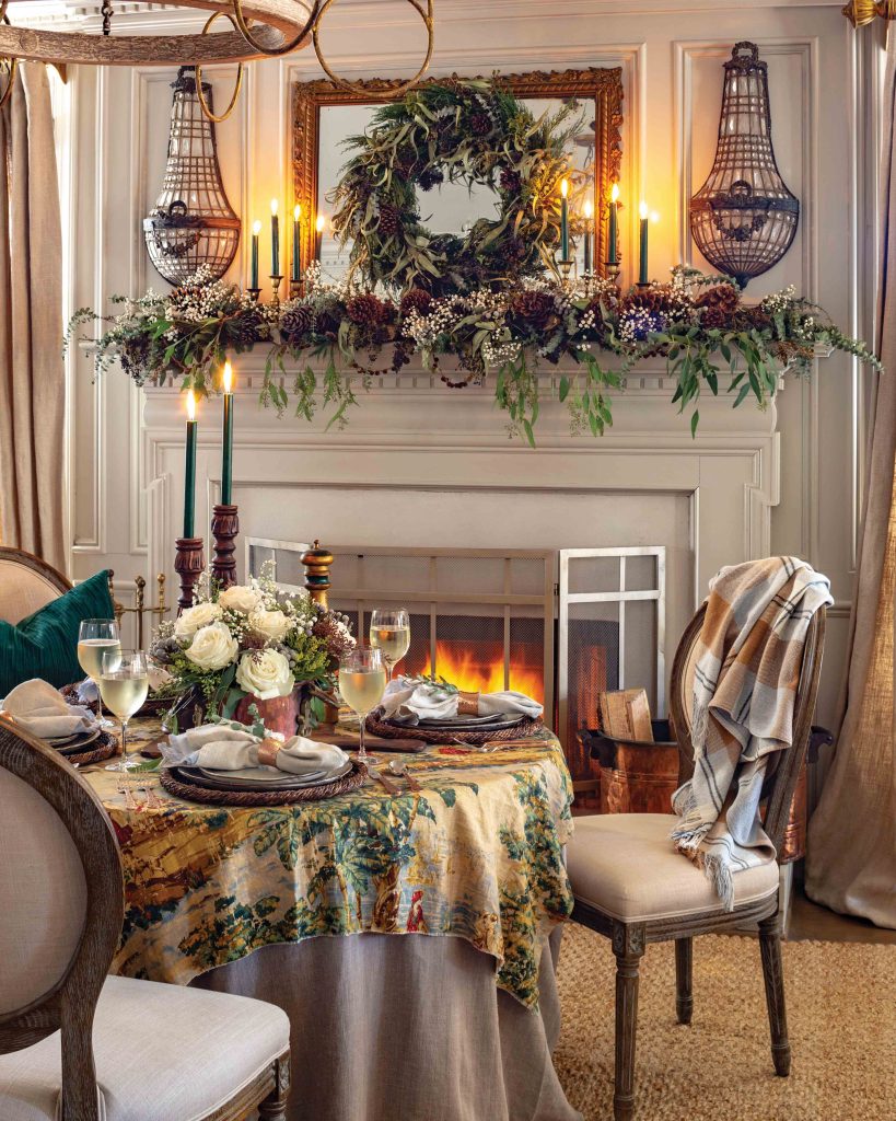 A comforting table sits beside the fire, with candles on the table.