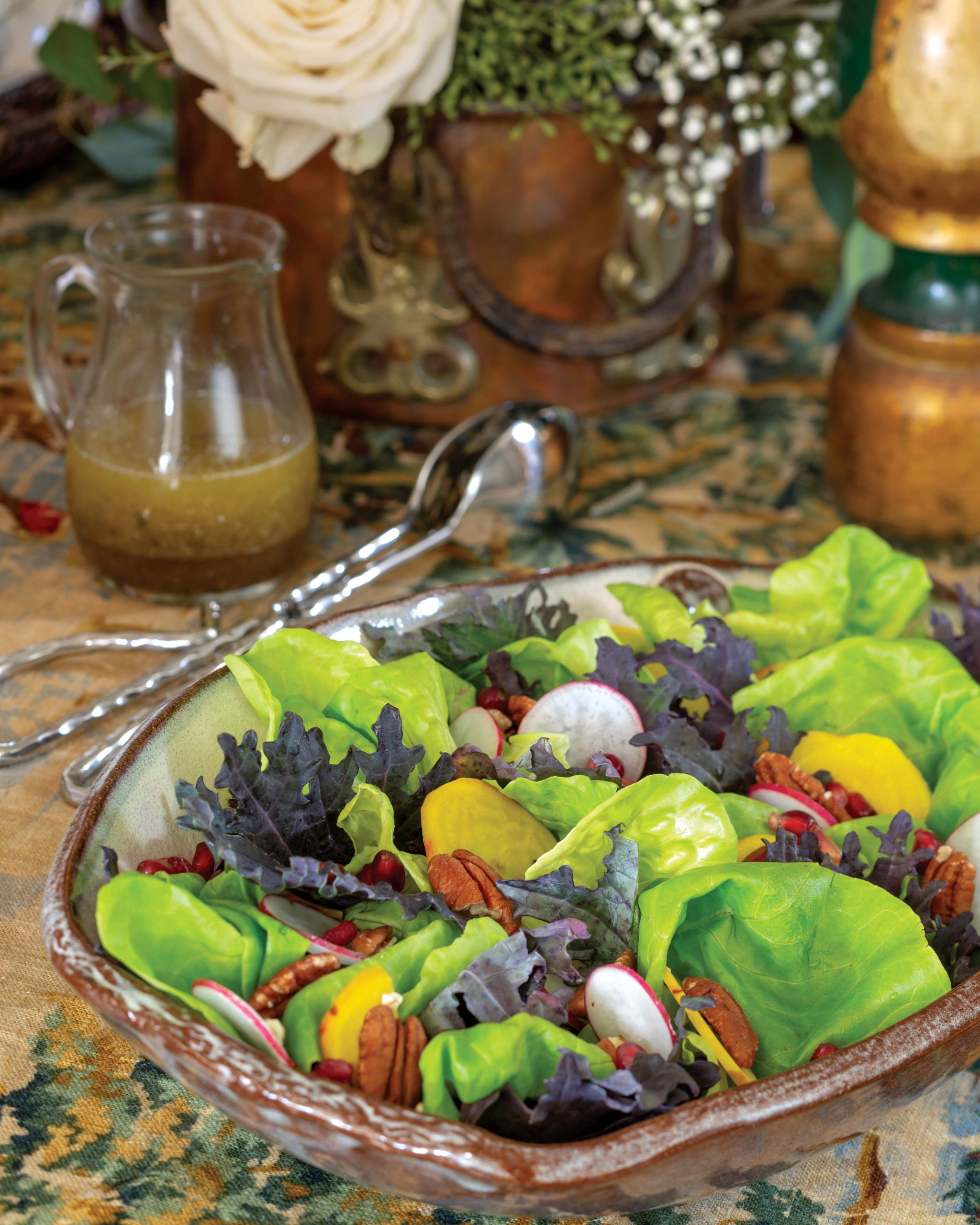 Bright green lettuce sits mingled with winter vegetables in a rustic bowl atop the table.