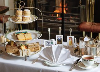 An arrangement of special dishes for teatime is displayed atop the table alongside the art each dish is meant to imitate or represent.