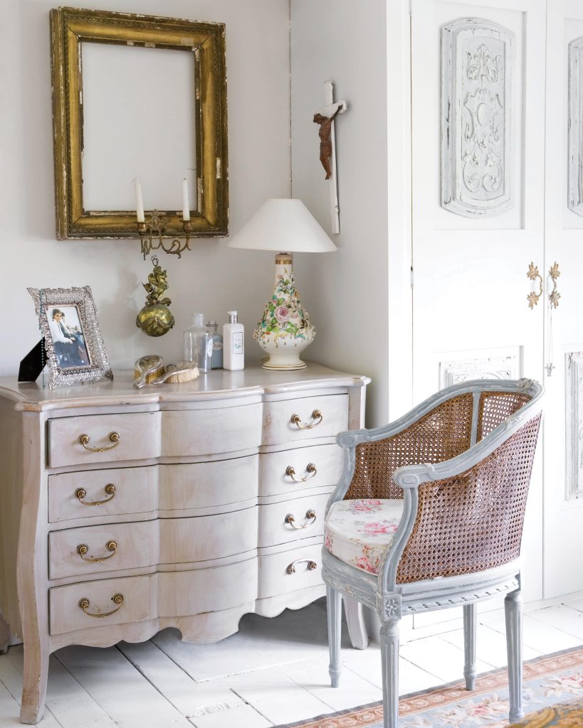  Used as a vanity, this dresser sits beside a wardrobe and a lovely cane chair.