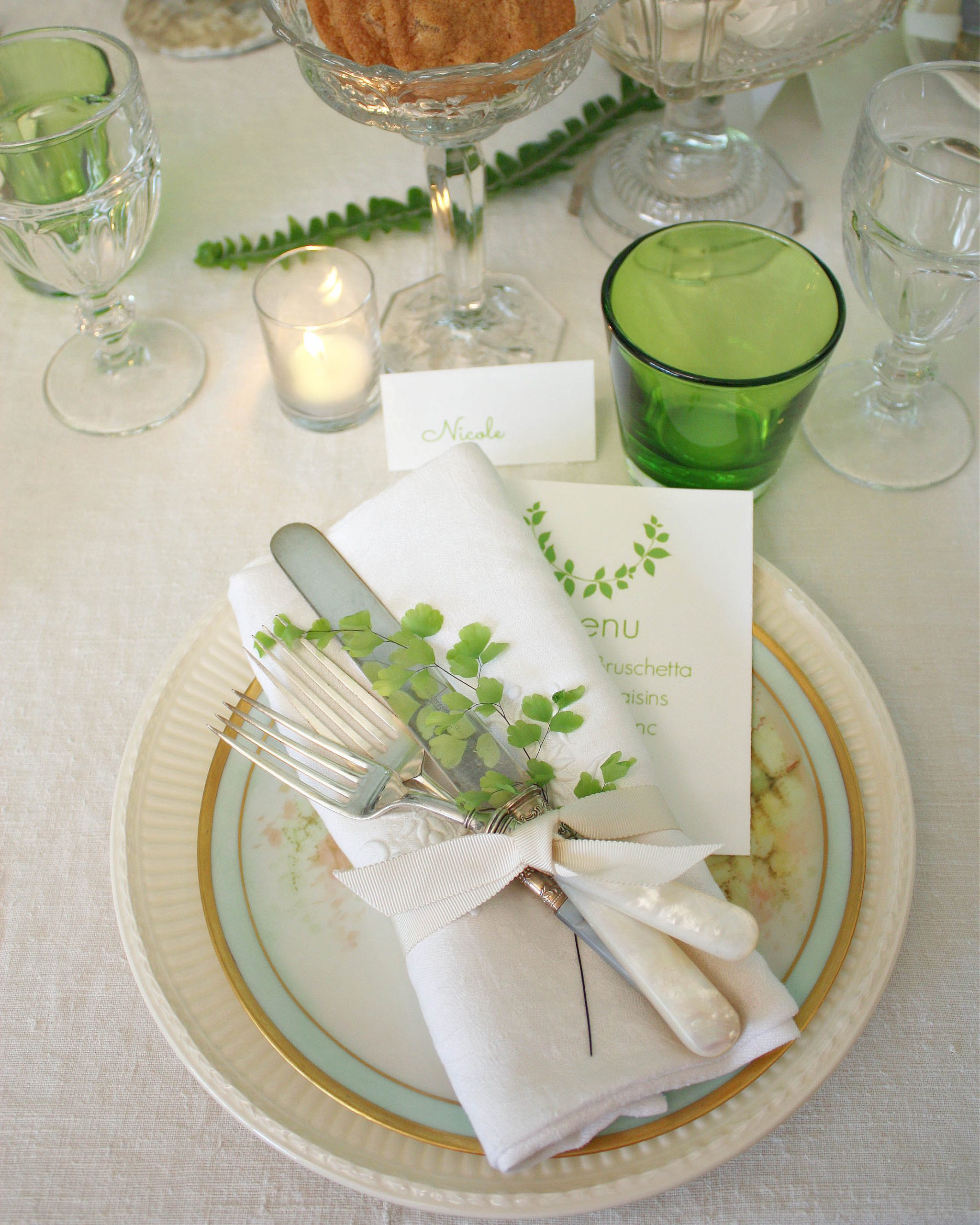 A place card and menu at each guest’s seat echo the green theme with images of the same type of greenery tucked into the napkin.