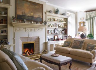 French antiques mingle in this stunning living room, where a cozy fire crackles in the hearth.