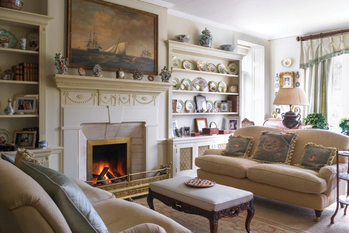 French antiques mingle in this stunning living room, where a cozy fire crackles in the hearth.