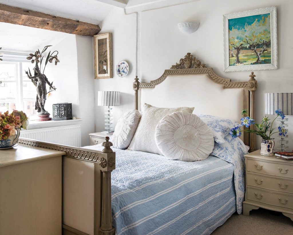 Neutral hues balance with calming blue linens in this bedroom.