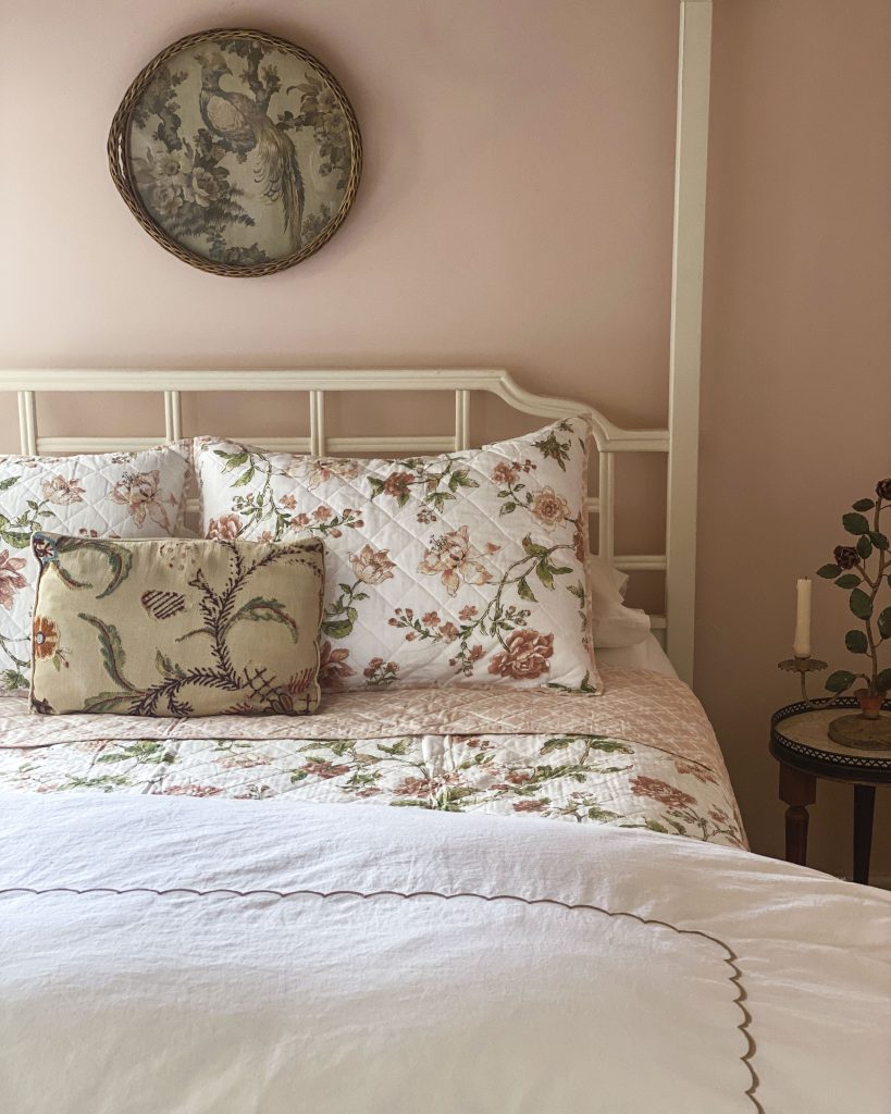 In Jenny Bohannon’s primary bedroom, a decorative pillow echoes the natural motifs highlighted in the artwork that hangs above the bed.