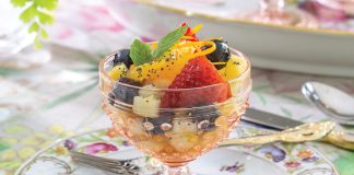 Sitting atop a floral plate, a compote made from blush-toned glass spills with fresh berries and more in our Springtime Fruit Salad.