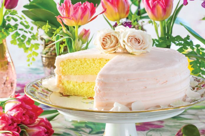 A porcelain cake tray displays this yellow treat iced in pale rose color.