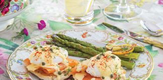 Two recipes—Smoked Salmon Eggs Benedict and Roasted Asparagus—are plated together at this table setting.