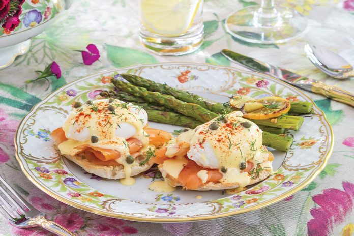 Two recipes—Smoked Salmon Eggs Benedict and Roasted Asparagus—are plated together at this table setting.