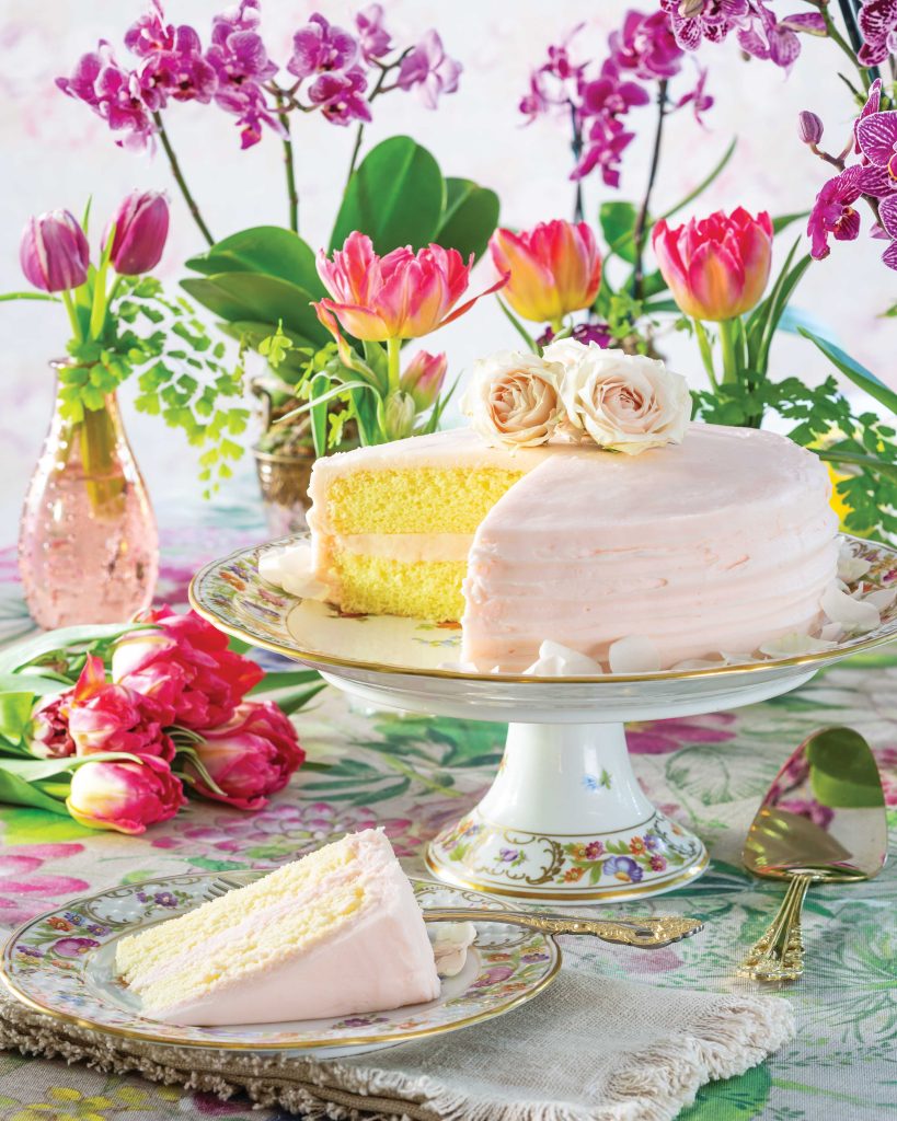 A porcelain cake tray displays this yellow treat iced in pale rose color.