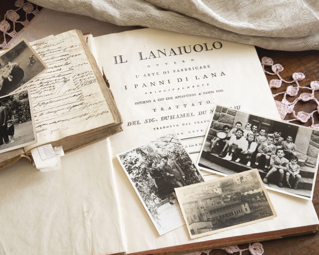 A vignette features an open book, a ledger, and assorted family photographs, all portrayed in sepia tones.