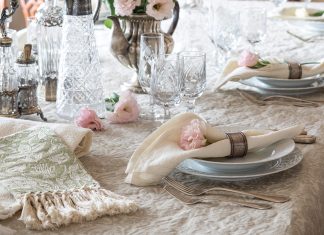 A formal table is set with elegant china, crystal, and Busatti linens in creamy shades of ivory.