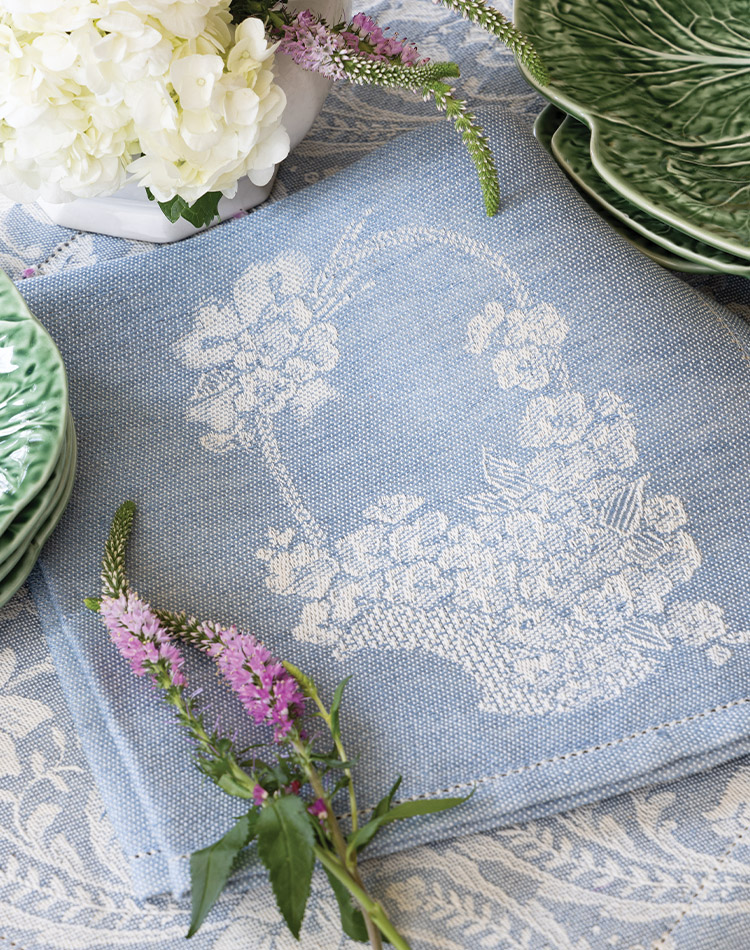 A powder blue exclusive Busatti linen napkin graced by lavender and white hydrangea. 