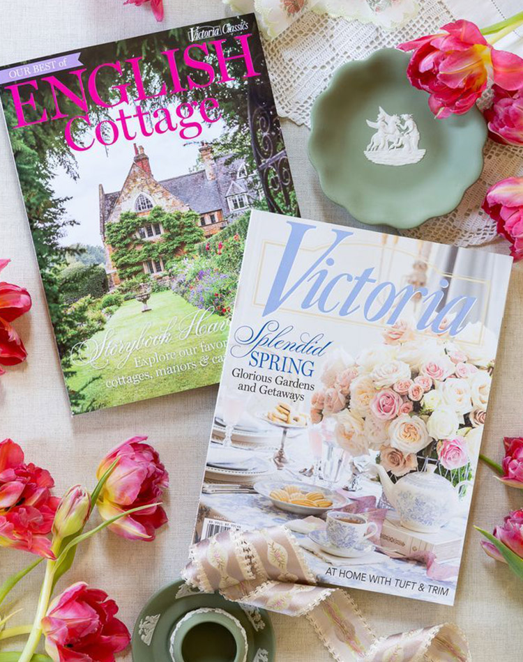 Two issues of Victoria Magazine, including English Cottage, displayed on spring flowers.