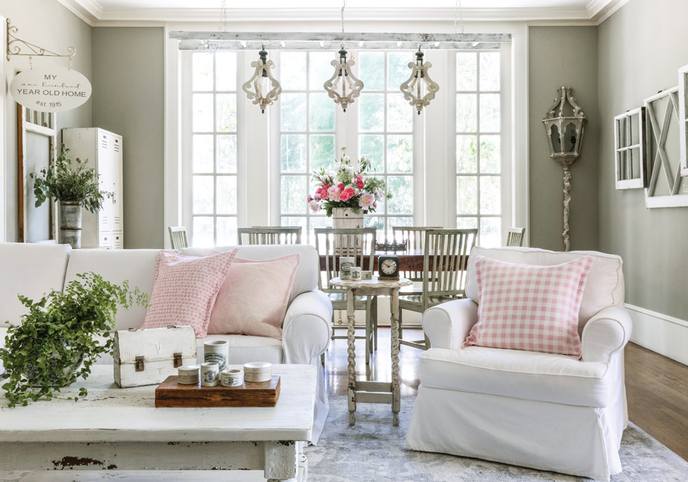 Leslie Saeta’s family room is flooded with natural light that adds even more of a bright and airy feel to the space decorated in creams and whites. The sofa and nearby chair are decorated with pink gingham throw pillows that create a comfortable sitting area.