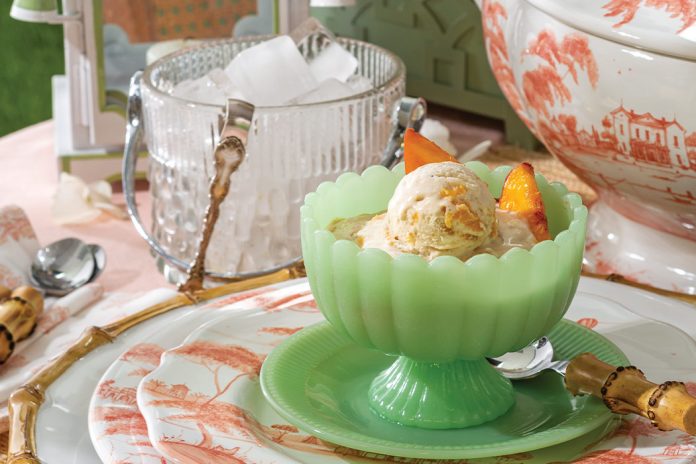 Fresh peach slices top scoops of Peaches Foster Ice Cream.