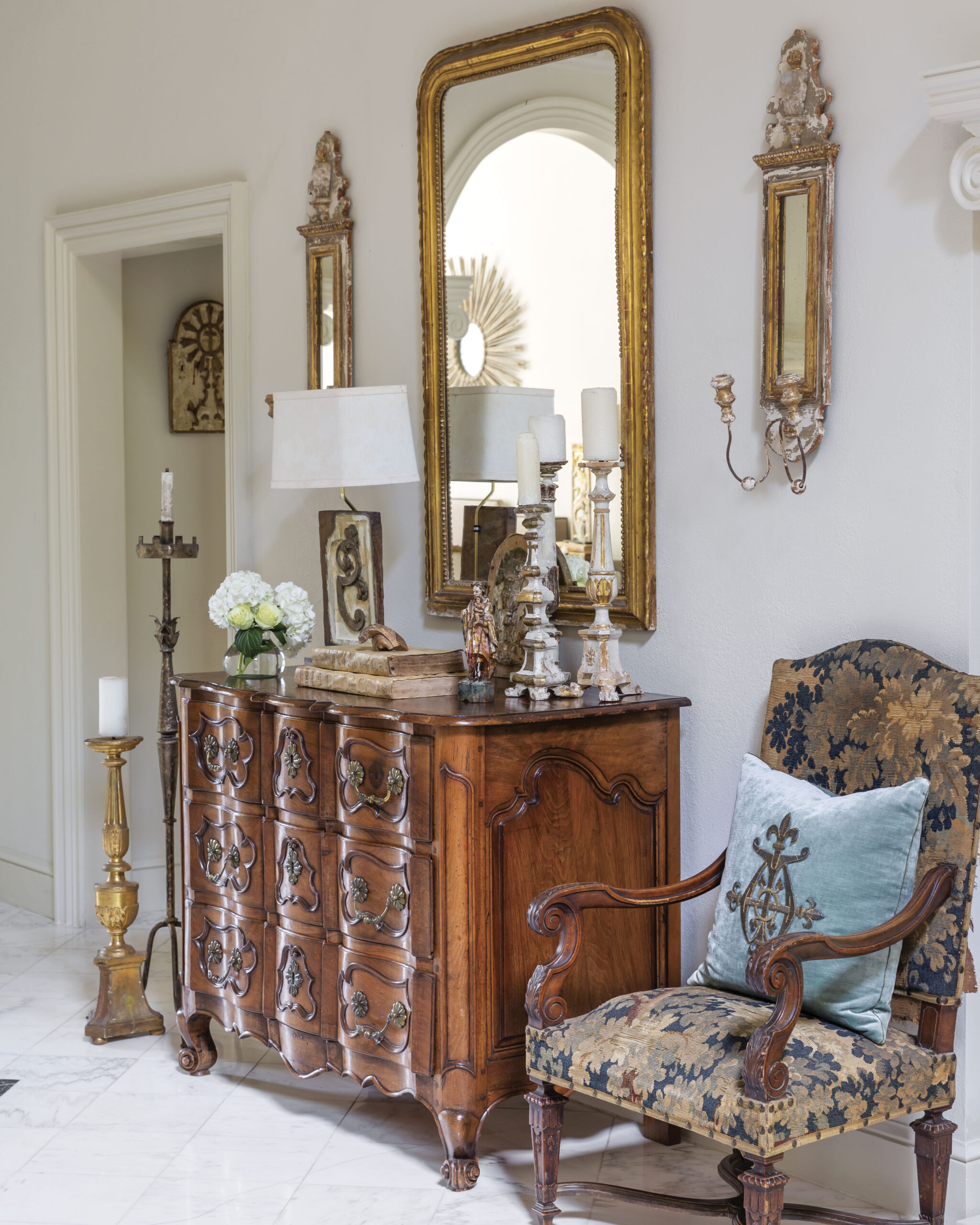 This nook is dressed in antique treasures, from pillows bearing ancient embroidery to gilt sconces and beyond.