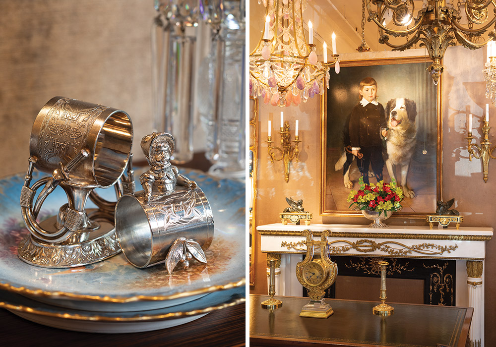 Left: Silver napkin rings with intricate raised details sit atop blue plates edged with gold. Right: A portrait of a boy and his dog hangs above a gold-and-white hearth.