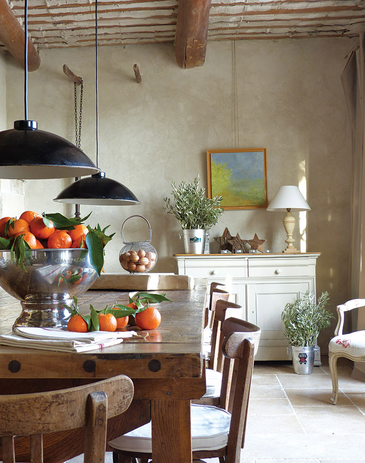 From the wooden table and chairs to the fresh fruit, greenery, and eggs, rural notes bring a sense of serenity to this dining room.