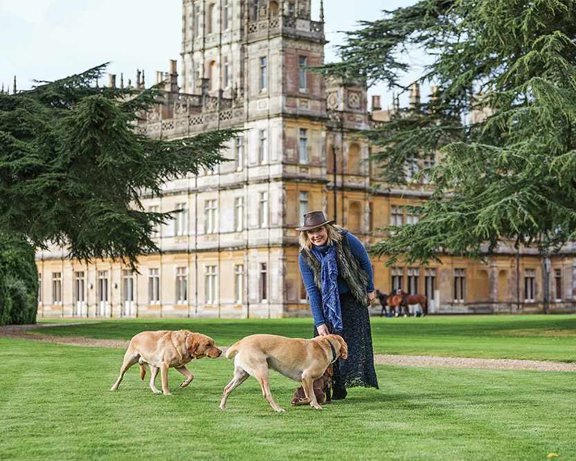 Lady Carnarvon walks a dog on the grounds of Highclere Castle