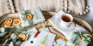Wrapped in Bliss: Victoria X Dogwood Hill: An antique Italian tray showcases tea, gift cards, gift tags, and packages wrapped in Blissful Holiday Collection gift wrap.