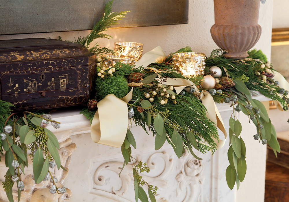 A white mantle laid with mistletoe and candlelight.