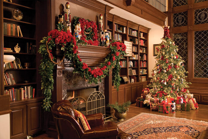 Holiday Bliss 2023 Preview. A decked mantle piece sits in the glow of a decorated Christmas tree.