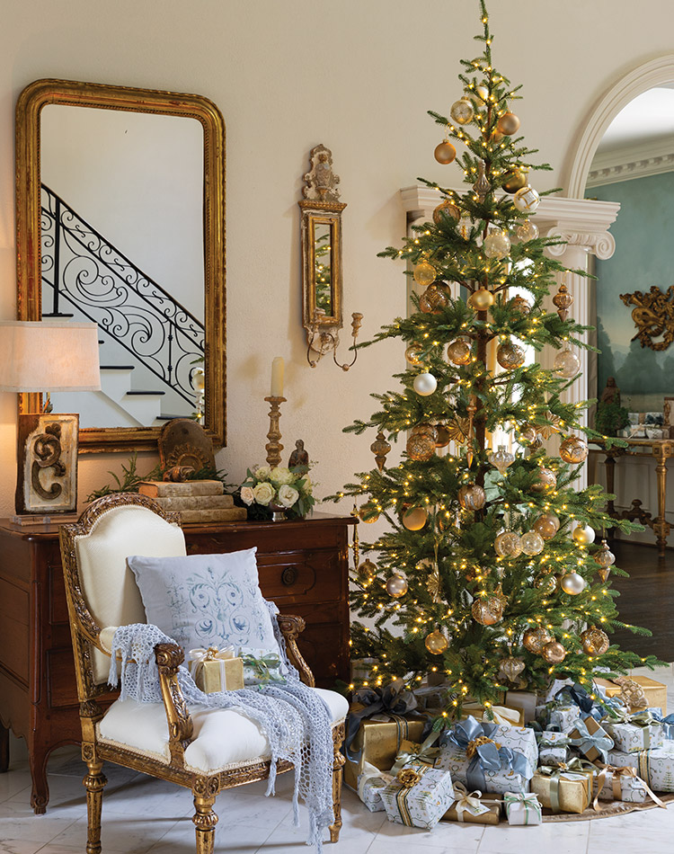 A quaint tree finds its home amid elegant surrounds, donned in gold and ivory orbs evocative of the glistening French treasures hung throughout the home.
