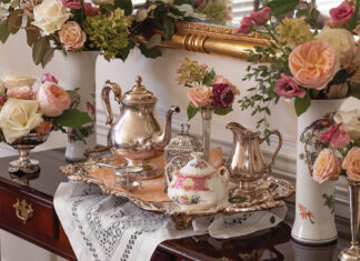 A silver tea service sits atop a wooden table, awaiting the finery of the experience that is afternoon tea.
