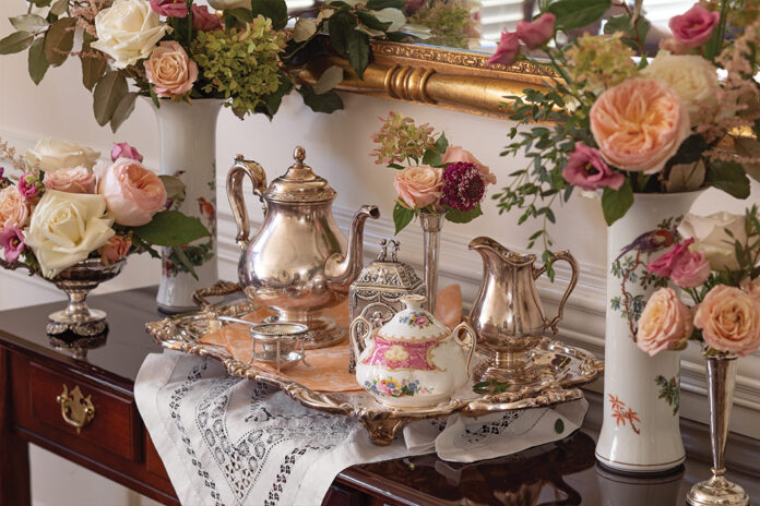 A silver tea service sits atop a wooden table, awaiting the finery of the experience that is afternoon tea.