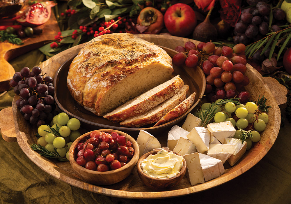 The aroma of fresh-baked Peasant Bread welcomes guests—a recipe reminiscent of the wood-fired loaves warmed in stone hearths centuries ago. However, for our variation, the modern availability of pre-packaged yeast allows for simpler preparation and a better rise in the dough. Served with softened butter, this rustic offering is fit for royalty.