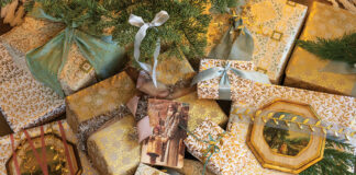 A mingling of blue, gold, and ivory wrapping adorn the cache of presents beneath one pastel tree this Christmas.