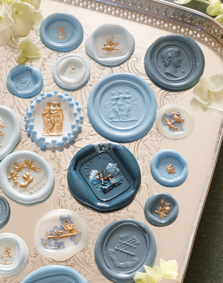 A mingling of individual seals, not yet placed atop an envelope, display blue-and-white examples of the many motifs in Kathryn Hastings & Co.’s collection.