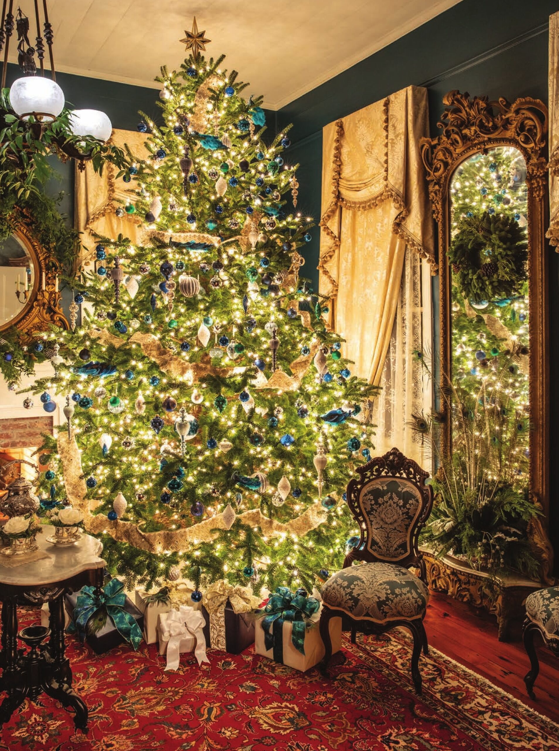 In this formal parlor of a historic southern home, a set of mid-nineteenth-century furniture by the renowned J. W. Meeks boasts traditional damask upholstery in a non-traditional hue. This was the inspiration for a custom paint color and crowd-pleasing contemporary tree covered in blue and silver ornaments, ivory ribbon, and peacock plumes.