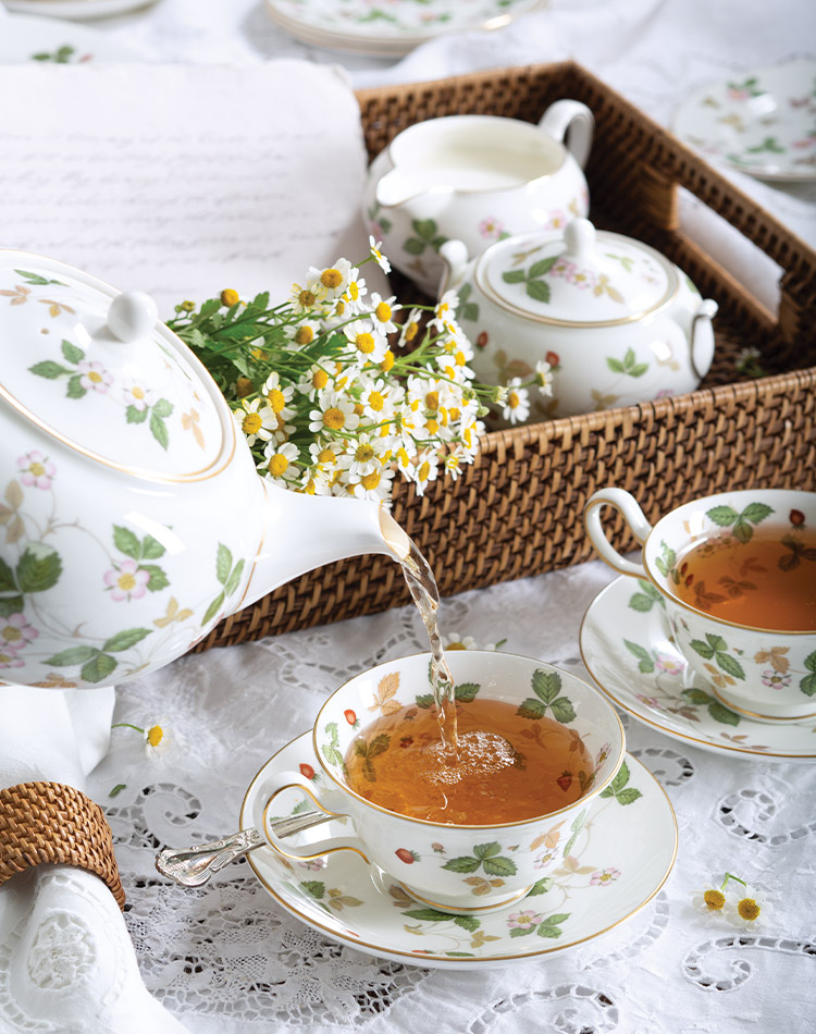 A strawberry patterned tea set serves a refreshing blend poured for afternoon tea.