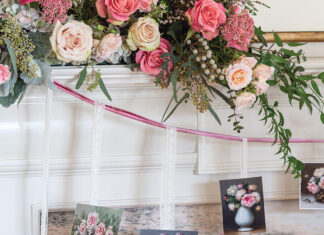 A lush arrangement of pink and white roses is nestled atop the mantel with a pretty garland made by hanging Valentine cards from wisps of ribbon.