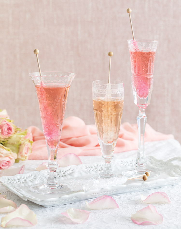 Crystal Champagne flutes filled with pink Champagne are adorned with Rock Candy swizzle sticks.